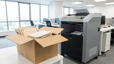 A cardboard storage box in a dusty garage with folders labeled Taxes 2014-2019