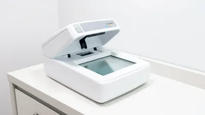 A professional fingerprinting station with a Live Scan machine, clean bright official setting