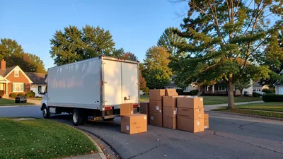 A moving truck on Route 306 near Kirtland Hills, moving boxes on a curb, trees and open sky in the background